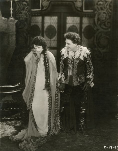 Maritana, a gypsy dancing girl played by Estelle Taylor, and Don Caesar de Bazan (William Farnum) are rather joyful in a scene still from the 1920 Fox production "The Adventurer." Farnum's costume is a lavish lace, velvet, and embroidery interpretation of a 17th century Spanish nobleman's dress.