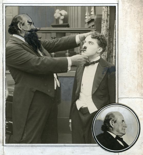 In this photo-collage, part of a promotional still from Charlie Chaplin's film "The Adventurer" with an actor wearing a huge false beard and moustache closely examining Chaplin's face is combined with a circular photograph of the actor without his beard. This paste-up apparently was made for Photoplay Magazine. The bearded actor was purported to be Eric Campbell in the caption. Strangely, the heads of the actor with and without makeup are not Campbell who was a younger and not nearly so bald man.
