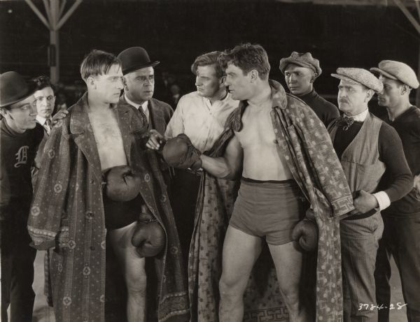 The boxer Tom Harper (played by Frank Mayo at left) has a tense meeting with his opponent Slick Morrisey (Al Kaufman) before their fight. They are flanked by a group of the sort of tough guys who hang around boxing rings.