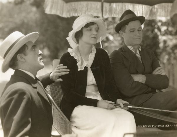 Zeb Sawyer, a wealthy mule dealer played by Ed Brady, is very interested in Eva McElwyn (Peggy Wood) who sits in a carriage with Sam Lyman (Will Rogers) in this scene still for "Almost a Husband."