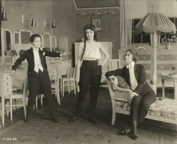 Three English girls who were raised as boys, from left to right: Tommy (played by Marguerite Clark), Willie (Eleanor Lawson), and Noel (Helen Greene) in a publicity still for "The Amazons." They wear men's evening dress: white ties, white waistcoats, and tailcoats.