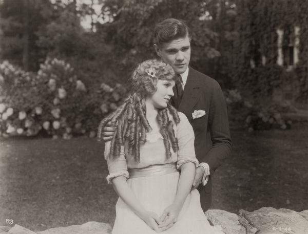Mary Miles Minter (playing Anne Shirley) snuggles with Paul Kelly (Gilbert Blythe) in a scene still for "Anne of Green Gables."