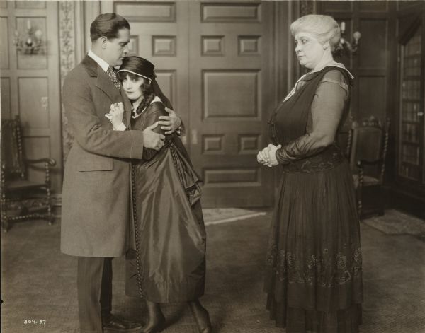 Robert Chappell (played by Jack Mower) comforts Ann Anderson (Margarita Fischer, costumed in mourning clothes) as Madame D'Arcy watches (Adelaide Elliot) in a scene still from the silent film "Ann's Finish."