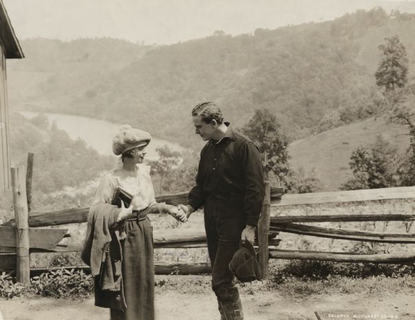 In this scene still from the 1918 Goldwyn production "Back to the Woods," Stephanie Trent (played by Mabel Normand) a rich man's daughter pretending to be a country school teacher meets Jimmy Raymond (played by Herbert Rawlinson) who is a novelist pretending to be a country boy.