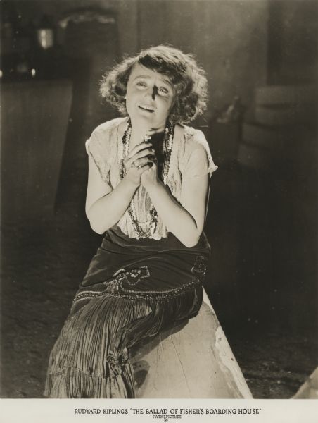 The prostitute called Anne of Austria, played by Mildred Owens, clasps a small cross and cries in a scene still for "The Ballad of Fisher's Boarding House." This silent film was Frank Capra's directorial debut.