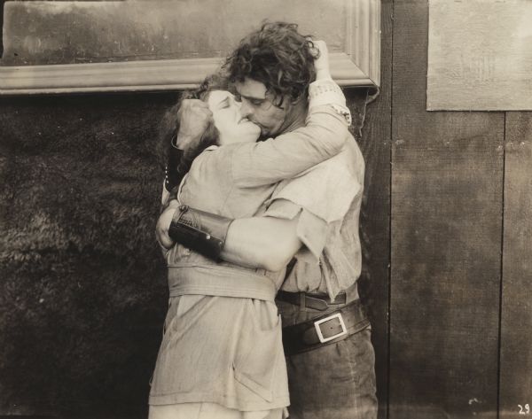Mildred Manning (played by Anna Luther) kisses ranch owner Del Burton (George Walsh) in a scene still for "The Beast" (Fox 1916).
