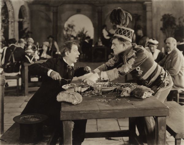 The undertaker Sobini (played by Billy B. Van) struggles for the spaghetti with Dr. Arbutus Budd (Raymond Hitchcock) in a scene still for the silent 1922 comedy "The Beauty Shop."
