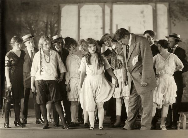 The young actress Dolly Lane (played by Mary Pickford) rehearses onstage  with a dozen or so other actors in the chorus in a scene still for the silent drama "Behind the Scenes."