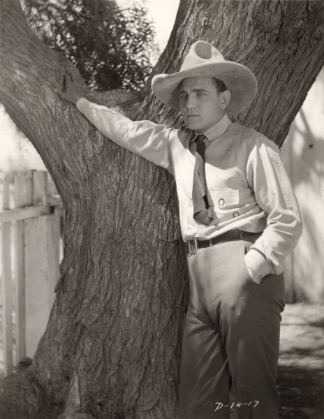 Fox silent film star Charles Jones, later known as Buck Jones, poses outdoors in a cowboy hat in a publicity still for the 1922 silent western "Bells of San Juan."
