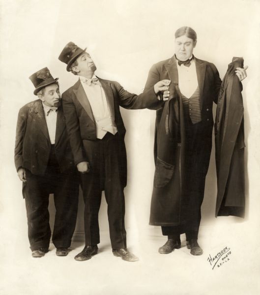 Joe Weber, left, watches as Lew Fields hands a butler his overcoat in a publicity still used to promote the 1915 Keystone comedy "The Best of Enemies."
