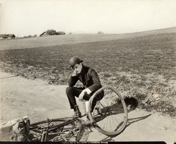 It is a disastrous day for traveling salesman Bill Henry Jenkins (played by Charles Ray) who has just wrecked his bicycle in a scene still for the silent comedy "Bill Henry."