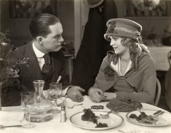 At lunch in a restaurant, Cuthbert King (played by David Howard) asks his sister Phyllis King (Mary Miles Minter) for a loan to pay his gambling debts in a scene still for the silent drama "A Bit of Jade."