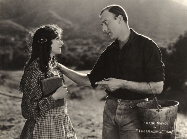 Talithy Millicuddy (played by Mary Philbin) looks lovingly at Bradley Yates (Frank Mayo) in a scene still for the 1921 silent drama "The Blazing Trail."