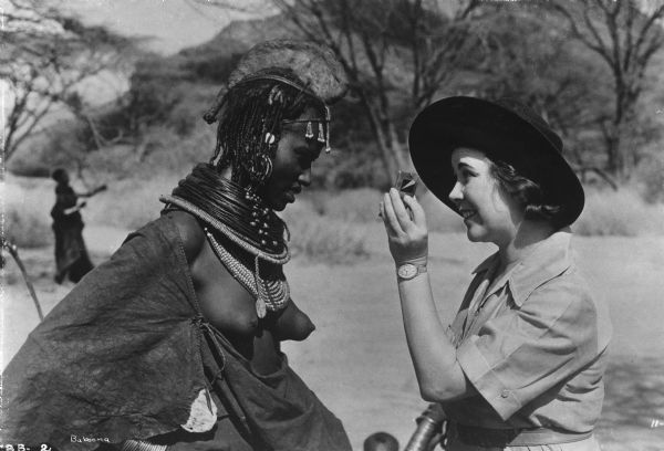 Osa Johnson shows an African woman, probably a Masai, how she looks in a pocket mirror in a scene still from "Baboona."