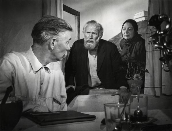 This production still by Hal McAlpin from the 1943 Goldwyn production "The North Star" was a first prize winner in the Academy of Motion Picture Arts and Sciences Hollywood Studios' Third Annual Still Photography Show (Class 3A: best posed production still in a studio). From left to right the actors are Walter Huston, Walter Brennan, and Ester Dale.
