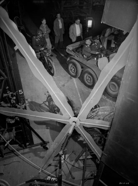 High angle view from behind a rotating gobo of Eric von Stroheim and Martin Kosleck sitting in the back seat of a military vehicle for the 1943 production "The North Star."