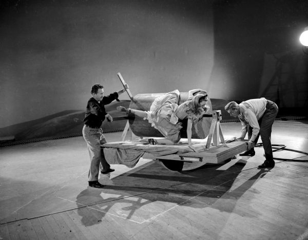 Child actress Kathryn Beaumont falls as one Disney studio technician rotates the cylinder she is on and another technician rocks the platform. Her fall is being filmed in the first step to rotoscope a sequence for the animated feature "Alice in Wonderland."