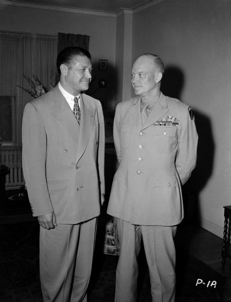 Hollywood motion picture producer Jules Levey and General Dwight Eisenhower pose for a publicity photograph. The occasion is a special December 1945 showing of "Abeline Town" in Washington D.C. for the general and his guests. Abeline, Kansas, was Eisenhower's home town.