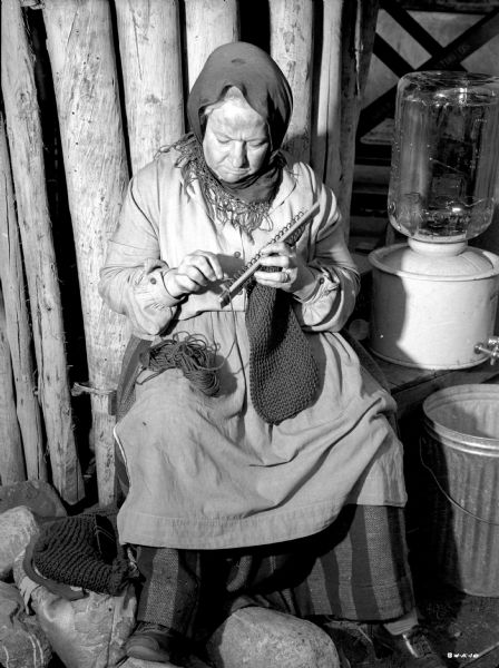 An unidentified actress costumed as a villager uses a Ukrainian knitting loom in a publicity still for "The North Star."