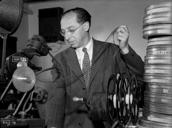 Composer Aaron Copeland examines a yard of 35mm optical soundtrack from a Moviola editing machine in a production still for "The North Star."