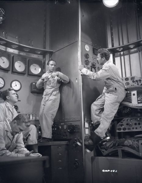 "Destination Moon" scene still with the actors Warner Anderson, Tom Powers, Dick Wesson, and John Archer in the control room of a spaceship. Wesson and Archer appear to be fighting.