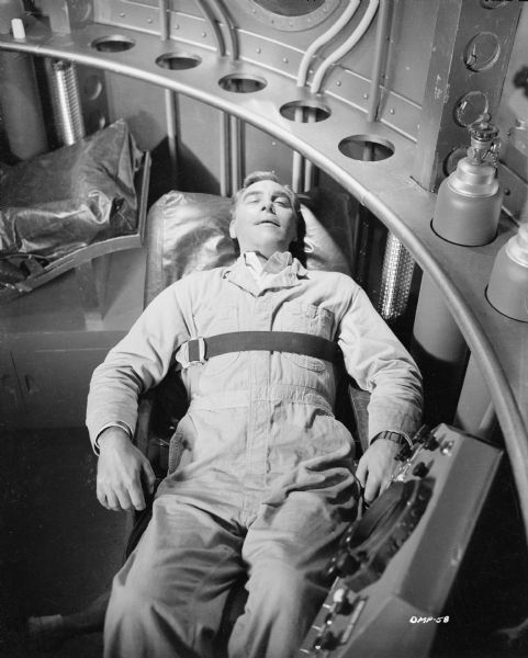 Actor Warner Anderson is strapped to a bunk in a spaceship in a scene still for "Destination Moon."