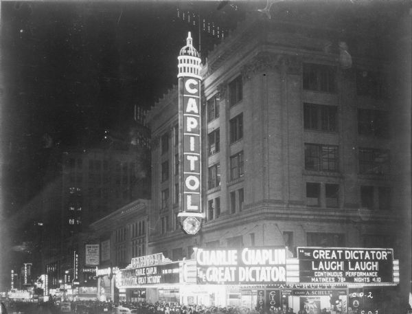 Crowds gather under the marquee of the Capitol Theatre for the New York premiere of Charlie Chaplin's "The Great Dictator" the evening of October 15, 1940. The photograph was taken catercorner from the theater at the intersection of West 51st Street and Broadway. Tickets for a matinee cost .75, for an evening showing, $1.10.
