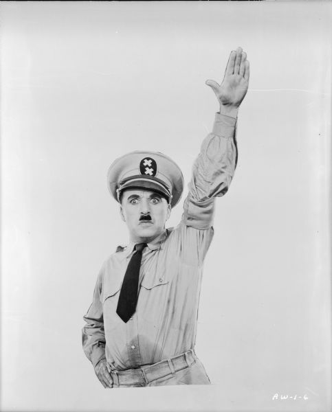 This photographic element of a poster design shows Charlie Chaplin's Hynkel character from the waist up in a military uniform. He is making a Nazi salute, the Hitlergruß.