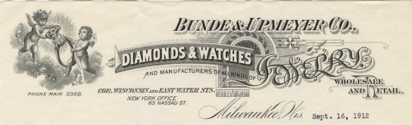Letterhead of the Bunde & Upmeyer Company of Milwaukee, Wisconsin, with two putti setting a ring with a radiating, faceted gemstone. They are hovering amidst clouds with flowers at their feet. Letterhead text is displayed in various typefaces, distinct fields, and printer's ornaments.