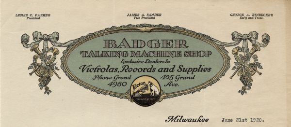 Letterhead of the Badger Talking Machine Shop in Milwaukee, Wisconsin, "exclusive dealers in Victrolas, Records, and Supplies," with a center oval medallion with the Victor logo ("His Master's Voice"), flanked by groupings of musical instruments, including a tambourine, horns, and Pan's pipes tied together with ribbons and flowers. Printed in green, yellow, and black ink.