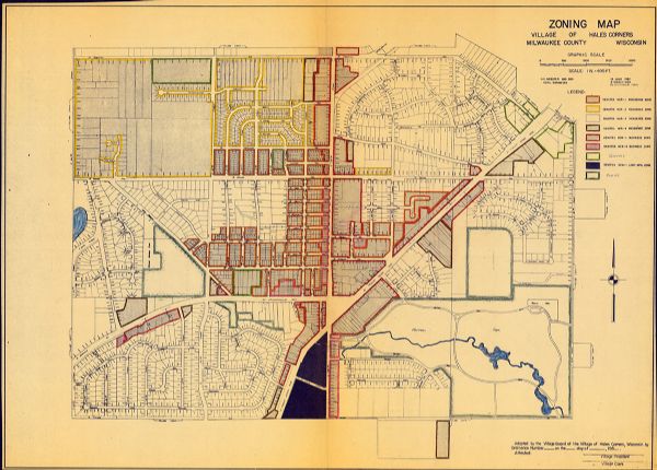 This map is a hand-colored blue line print and shows 4 residence zones, 2 business zones, 1 light manufacturing zones, schools, and parks. The zones are outlined in orange, yellow, brown, red, pink, green, blue, and a combination of blue and green.