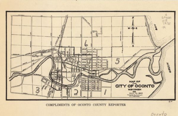 This map shows streets, railroads, and city wards. Streets, the Oconto River, and the Green Bay are labeled. The bottom of the map reads: "Compliments of Oconto County Reporter."