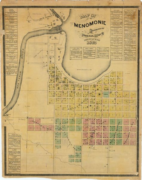 This plat map shows local streets, buildings, numbered blocks and lots, part of the Red Cedar River, and land ownership by name. Also included is a business directory and annotations in pencil and red ink.