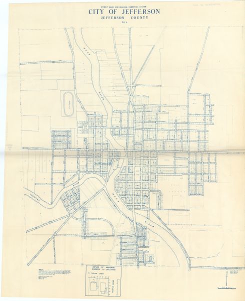 This blue line print map shows lot and block numbers and dimensions, fair grounds, schools, court house, parks, and the street numbering system. The Crawfish River, Rock River, and streets are labeled. An inset map shows methods of assigning numbers to buildings.