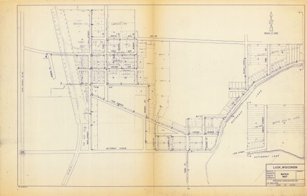 This blue line print map shows pipes, valves, well site, and elevation tank, as well as lot and block numbers and dimensions. The map includes inset of continued portion of Scow and Butts Addition to Luck.