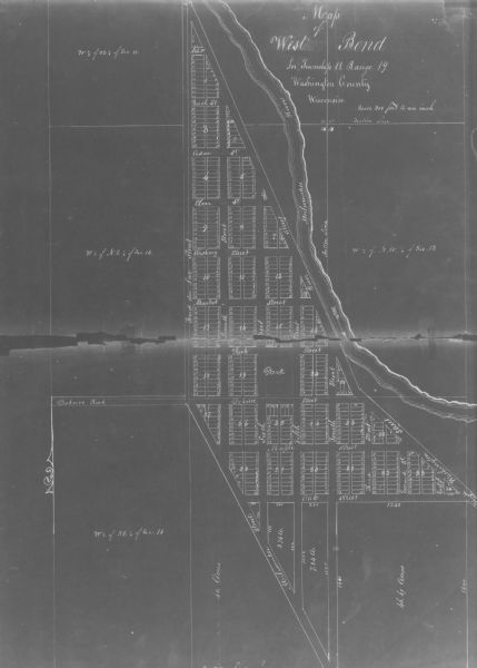 This map shows land parcels, streets and parks in the city of West Bend. The Milwaukee River is labeled on the left side.