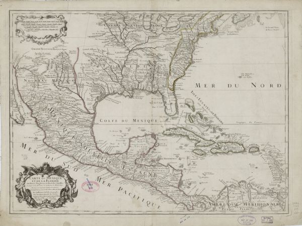Map of the Golf of Mexico and surrounding countries from the Great Lakes down to the northern most parts of South America. L'Isle labels cities, towns, and various geographical features. The territory of Florida is shown as extending from modern Florida to Texas, and the territories of England and some Native American groups are outlined or labeled. Lake Michigan is referred to as Lake Illinois. The border of the scale and title cartouche are decorated, the scale cartouche with scrolls, and the title cartouche with depictions of Native Americans, produce, an alligator, and bows and arrows. 