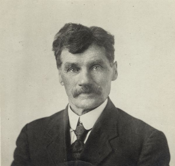Quarter-length portrait of unidentified man with a moustache. He is wearing a jacket, shirt and tie.