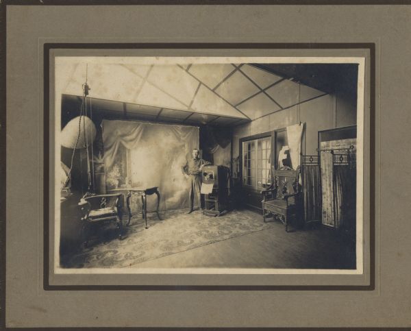 Matthew Witt stands next to one of his cameras in the interior of his photographic studio.
