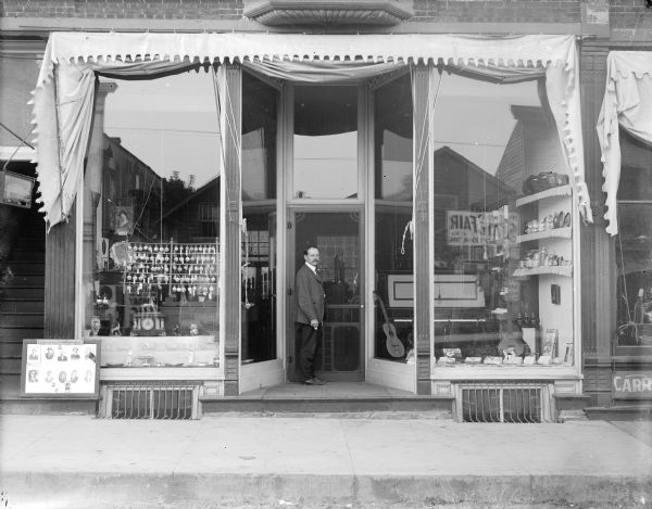 C.N. Oulie Jewelry Store located at 9 Main Street. Sign reflected in the window advertises the Wisconsin State Fair, September 10-14, 1906.	