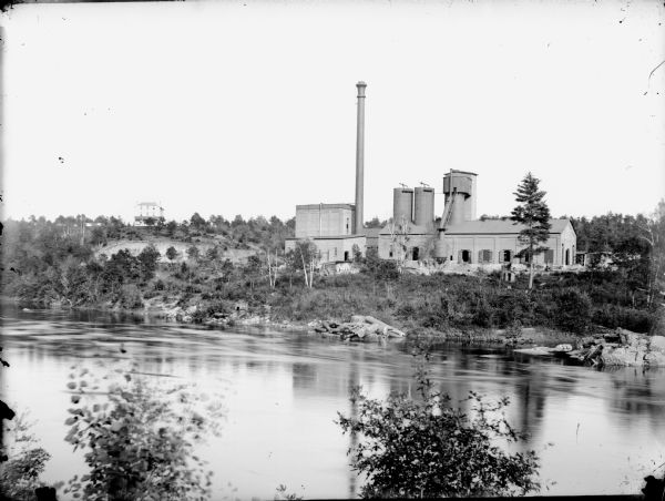 View across river of York Iron Works. On the hill are the boardinghouse and dance hall. Just below the boardinghouse there appears to be a quarry.