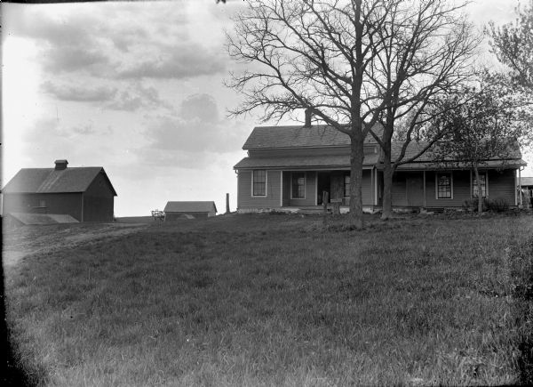 Frame house with barn and other farm buildings. There is a sign in front of the house for "Postum Food Coffee."