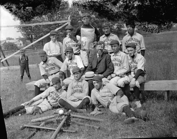 Swenson Grubber Baseball Team. There is an older man in the center who is probably Joe Carnahan, who sold the Swenson Grubbing Machine to remove stumps. In the second row seated on the bench, the first man on left is Jule Olson; and the first man on the right is Frank Snowden. In the back row, on the far right is Ernest Rudolph, Sr.
