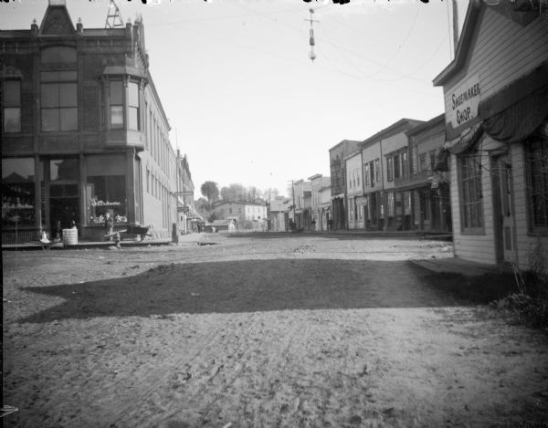 View down Main Street. The hardware store is on the corner on the left, the shoemaker shop is on the right, and the offices of "The Journal" are further down the street.