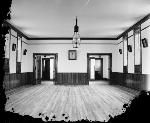 Interior view of a Masonic Lodge meeting hall. In the center on the wall is a framed document of the "Columbia Commandery." There are other framed portraits on the walls on the left and right.