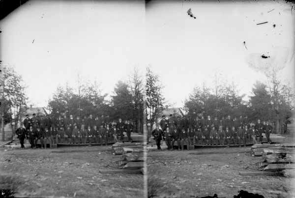 Stereograph of a large group of European American men posing standing outdoors.