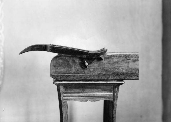 Studio portrait of an unidentified metal and wooden object. Probably a tool.