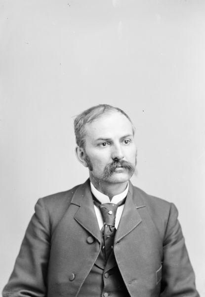 Waist-up studio portrait of an European American man posing sitting. Identified as Charles J. Van Schaick.