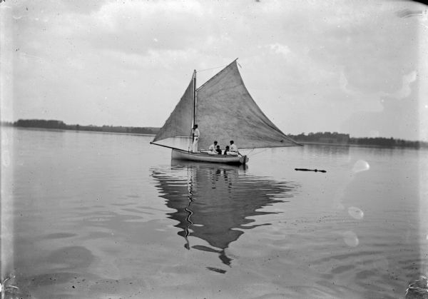 View across water towards five people on a sailboat. Identified as possibly near Hatfield.