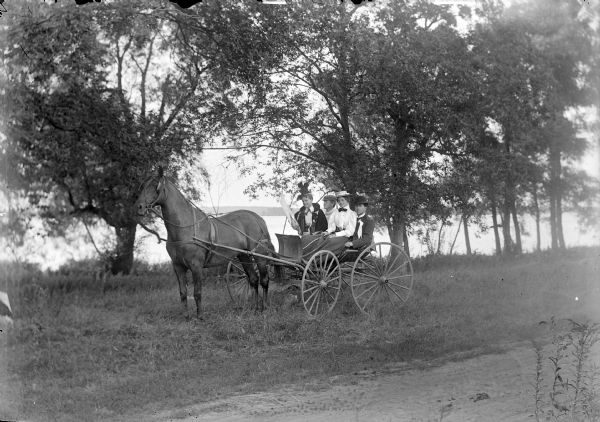 Two Women Sitting on the Laps of Two Men in a Buggy | Photograph ...